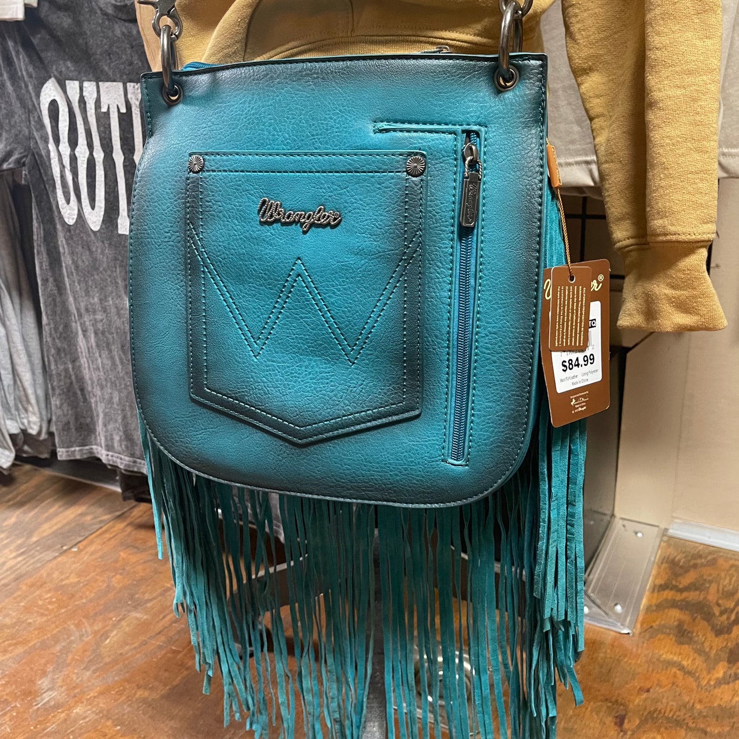 Back view of the turquoise rivet detailed crossbody bag showcasing the wrangler pocket and the zipper closure concealed carry compartment