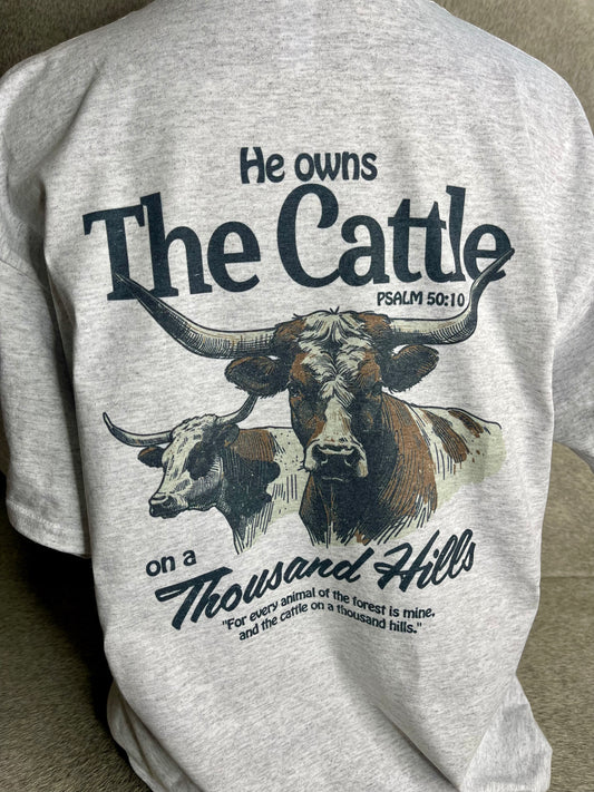A heather grey Jerzees unisex t-shirt featuring the Rowdy Herd logo on the front pocket area and a longhorn cattle design on the back, along with the quote from Psalms 50:10.