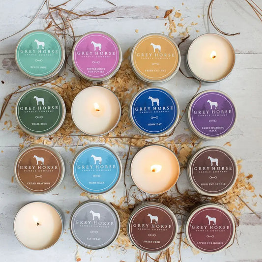 Multiple 6.3 ounce candle tins in multiple scents with some of the candles burning